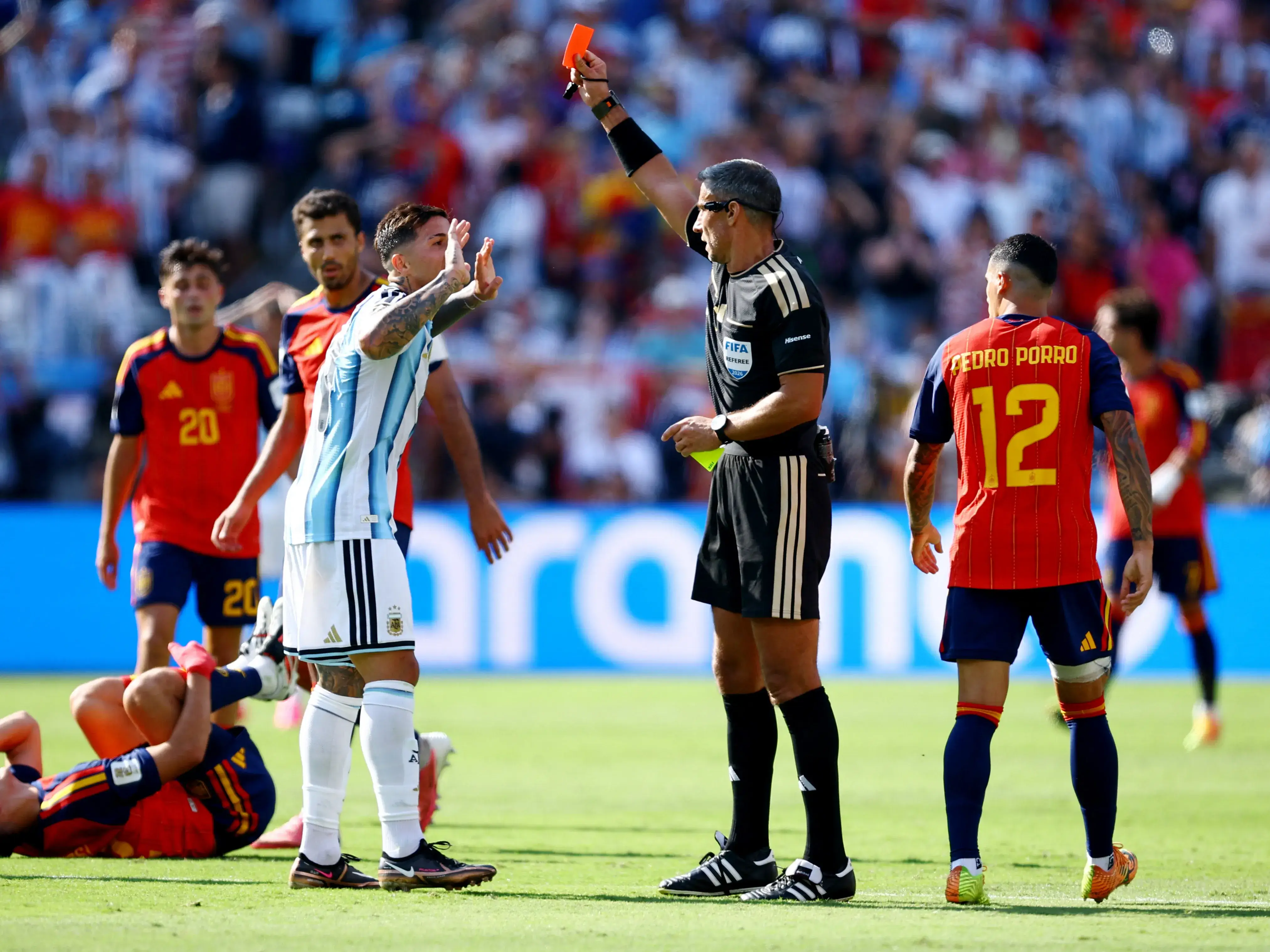 Referee issuing straight red card for excessive force or violent conduct showing referee raising red card high